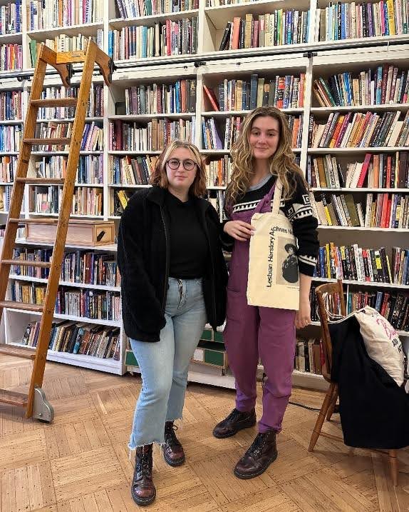 two figures standing in front of bookcases