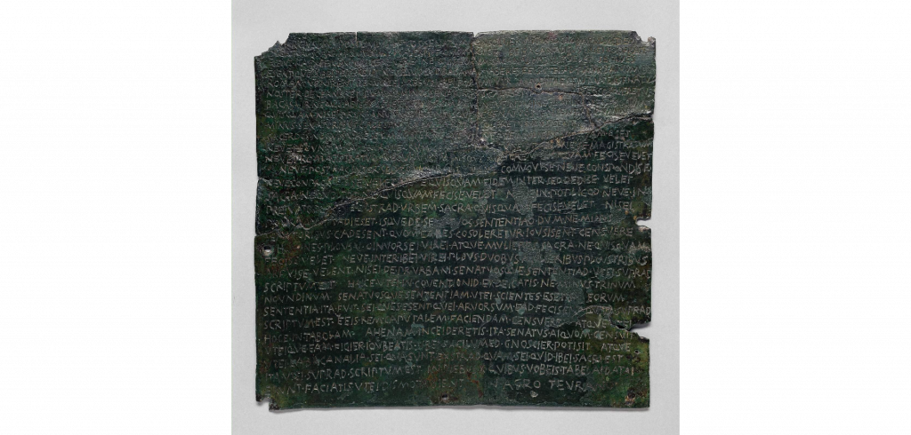 A photograph of a  bronze tablet with text in Latin